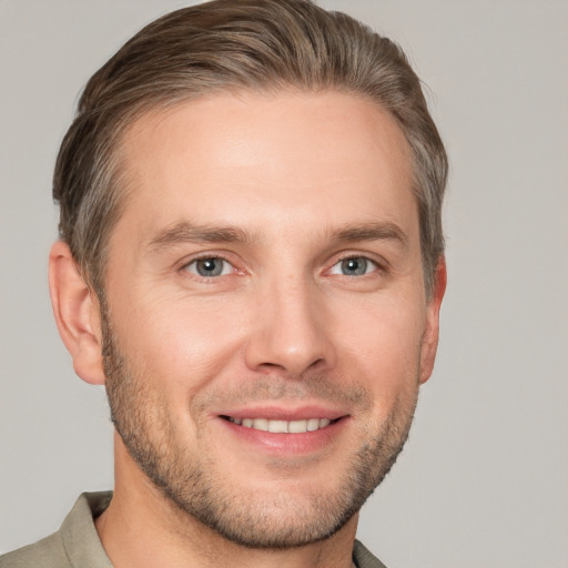 Joyful white young-adult male with short  brown hair and grey eyes