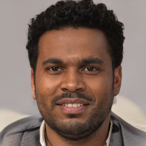 Joyful black young-adult male with short  black hair and brown eyes