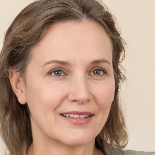 Joyful white adult female with medium  brown hair and grey eyes