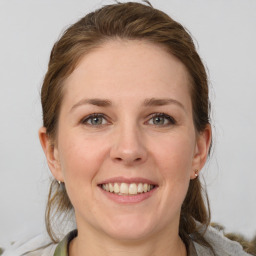 Joyful white young-adult female with medium  brown hair and grey eyes