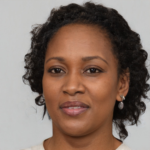 Joyful black adult female with medium  brown hair and brown eyes