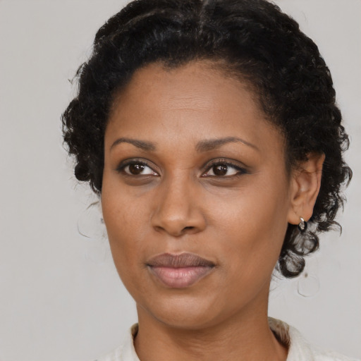 Joyful black adult female with short  black hair and brown eyes