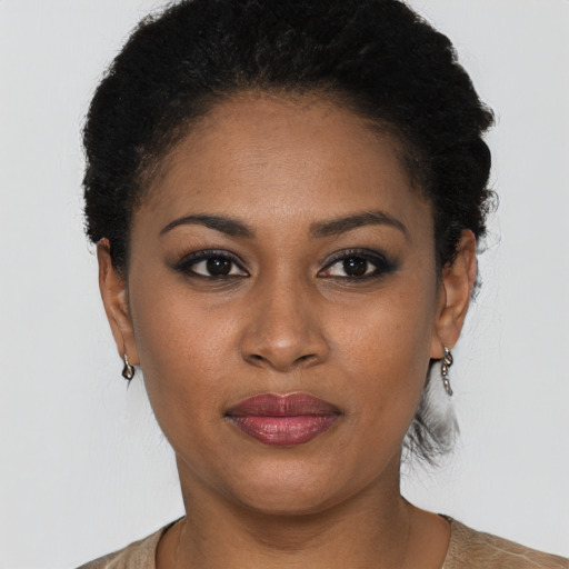 Joyful black young-adult female with short  black hair and brown eyes