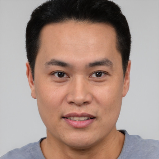 Joyful asian young-adult male with short  black hair and brown eyes