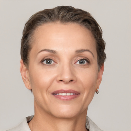 Joyful white adult female with short  brown hair and grey eyes