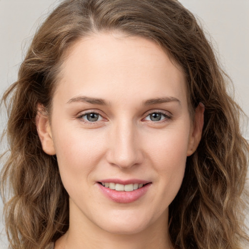 Joyful white young-adult female with long  brown hair and grey eyes