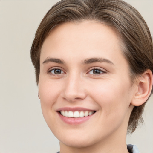 Joyful white young-adult female with medium  brown hair and grey eyes