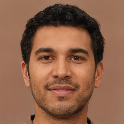 Joyful latino young-adult male with short  brown hair and brown eyes