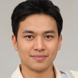 Joyful asian young-adult male with short  brown hair and brown eyes