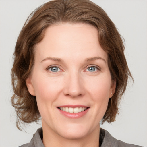 Joyful white adult female with medium  brown hair and grey eyes