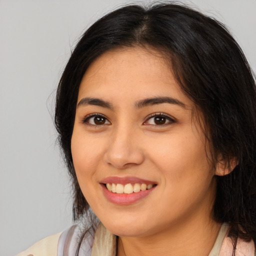 Joyful latino young-adult female with long  brown hair and brown eyes