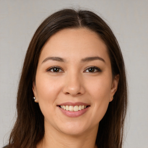 Joyful white young-adult female with long  brown hair and brown eyes