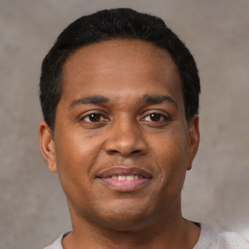 Joyful black young-adult male with short  black hair and brown eyes