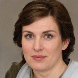 Joyful white adult female with medium  brown hair and green eyes