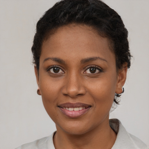 Joyful black young-adult female with short  brown hair and brown eyes