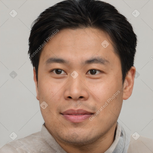 Joyful asian young-adult male with short  brown hair and brown eyes