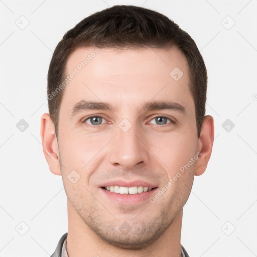 Joyful white young-adult male with short  brown hair and grey eyes