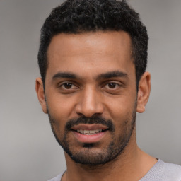 Joyful latino young-adult male with short  black hair and brown eyes