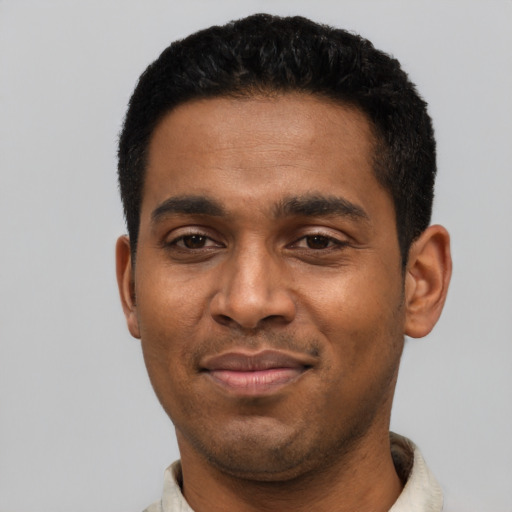 Joyful latino young-adult male with short  black hair and brown eyes