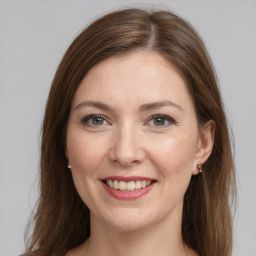 Joyful white young-adult female with long  brown hair and grey eyes