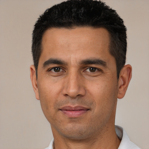 Joyful latino young-adult male with short  black hair and brown eyes