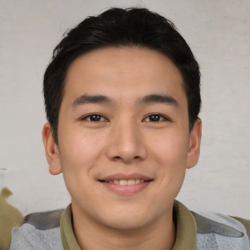 Joyful asian young-adult male with short  brown hair and brown eyes