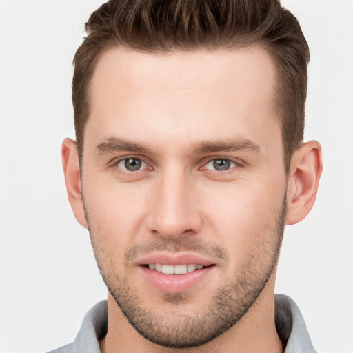 Joyful white young-adult male with short  brown hair and grey eyes