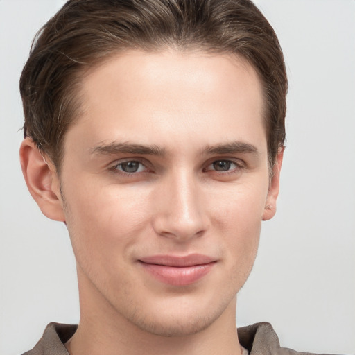 Joyful white young-adult male with short  brown hair and grey eyes