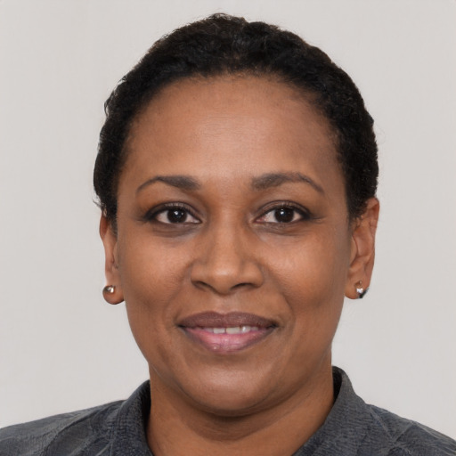 Joyful black adult female with short  black hair and brown eyes