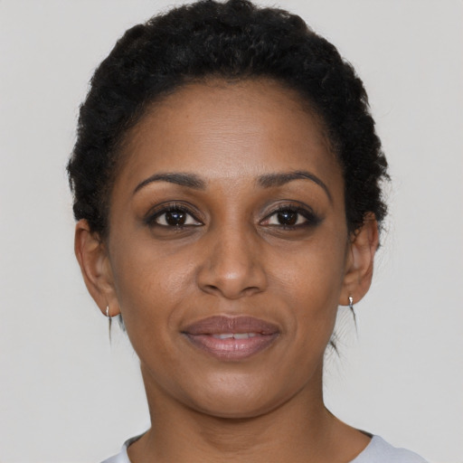 Joyful black young-adult female with short  black hair and brown eyes