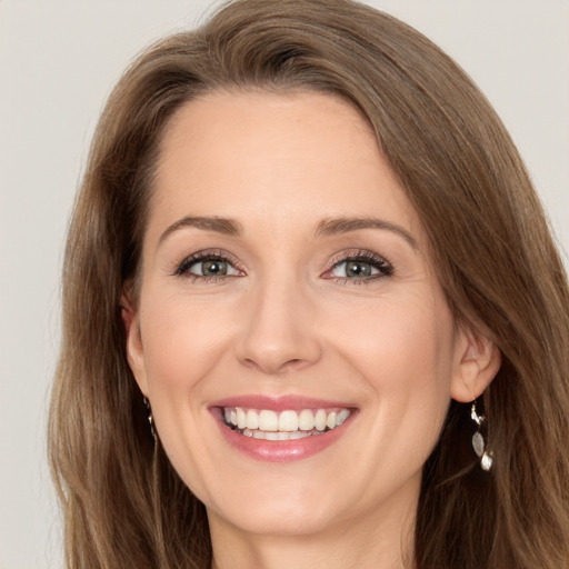 Joyful white young-adult female with long  brown hair and green eyes