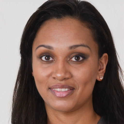Joyful black young-adult female with long  brown hair and brown eyes
