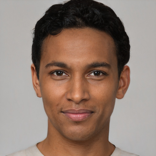 Joyful black young-adult male with short  black hair and brown eyes