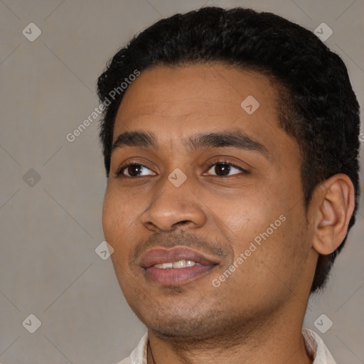 Joyful black young-adult male with short  black hair and brown eyes