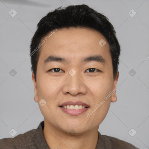 Joyful asian young-adult male with short  black hair and brown eyes