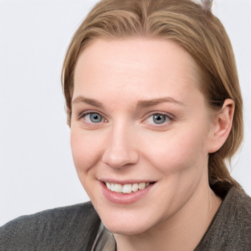 Joyful white young-adult female with short  brown hair and blue eyes