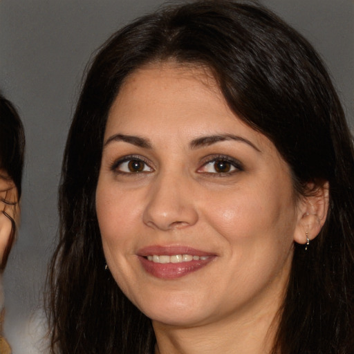 Joyful white adult female with long  brown hair and brown eyes