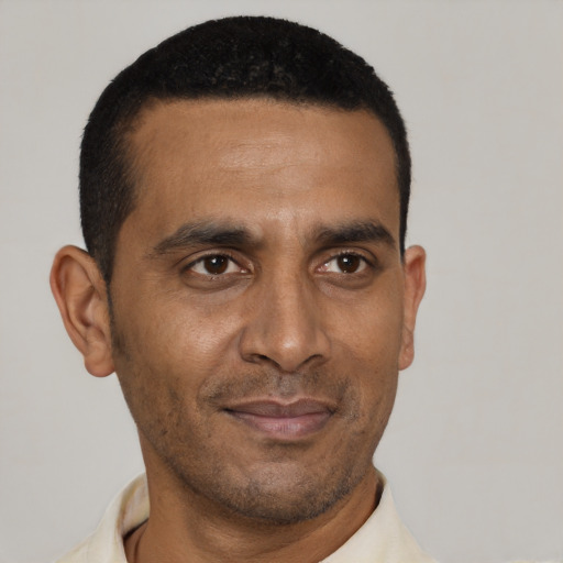 Joyful black adult male with short  black hair and brown eyes