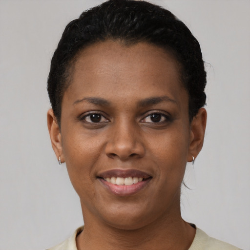 Joyful black young-adult female with short  brown hair and brown eyes