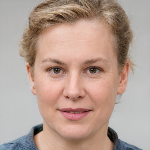 Joyful white adult female with short  brown hair and blue eyes