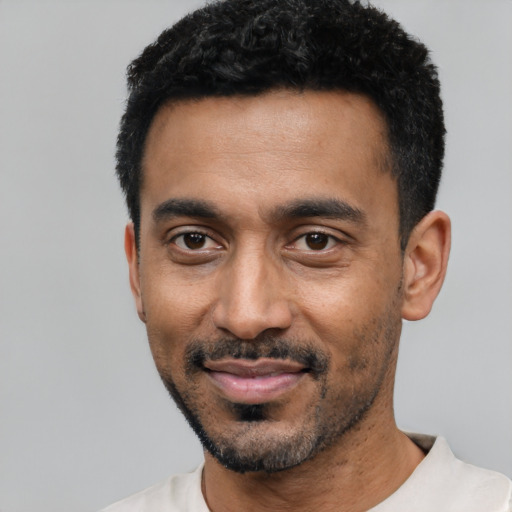 Joyful black young-adult male with short  black hair and brown eyes
