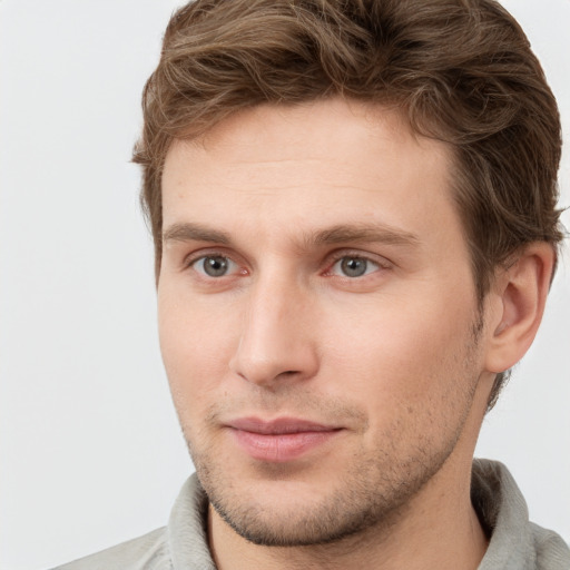 Joyful white young-adult male with short  brown hair and grey eyes