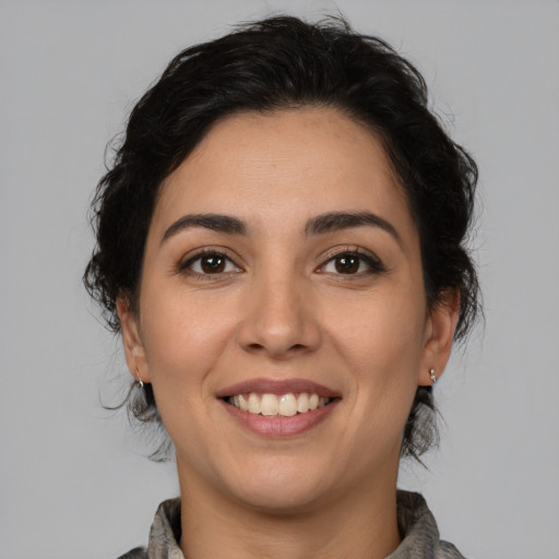 Joyful latino young-adult female with medium  brown hair and brown eyes