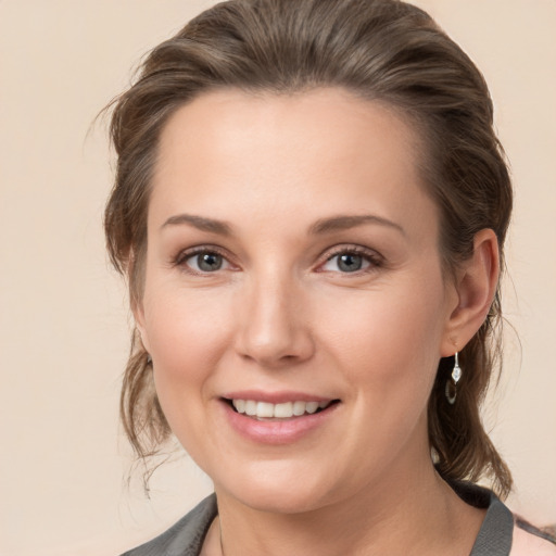 Joyful white young-adult female with medium  brown hair and grey eyes