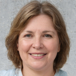 Joyful white adult female with medium  brown hair and grey eyes