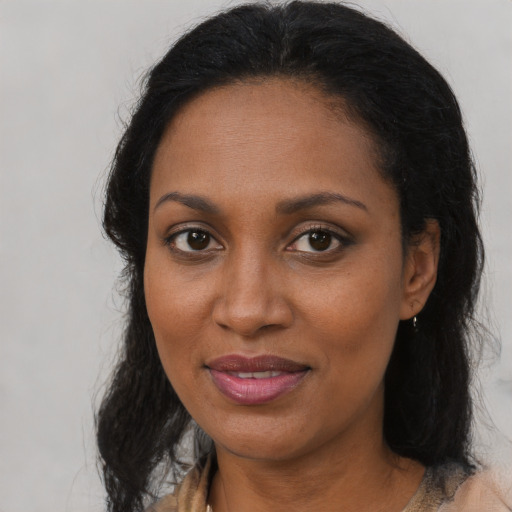 Joyful black adult female with long  brown hair and brown eyes