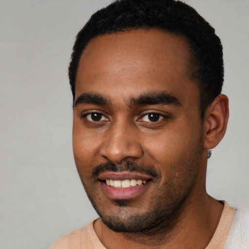 Joyful black young-adult male with short  black hair and brown eyes