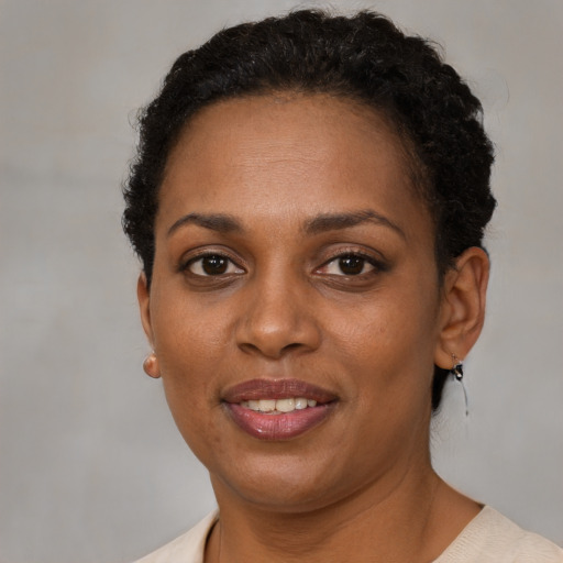 Joyful black adult female with short  brown hair and brown eyes
