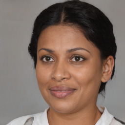 Joyful black adult female with medium  brown hair and brown eyes