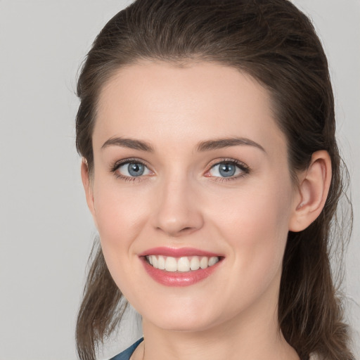 Joyful white young-adult female with medium  brown hair and grey eyes